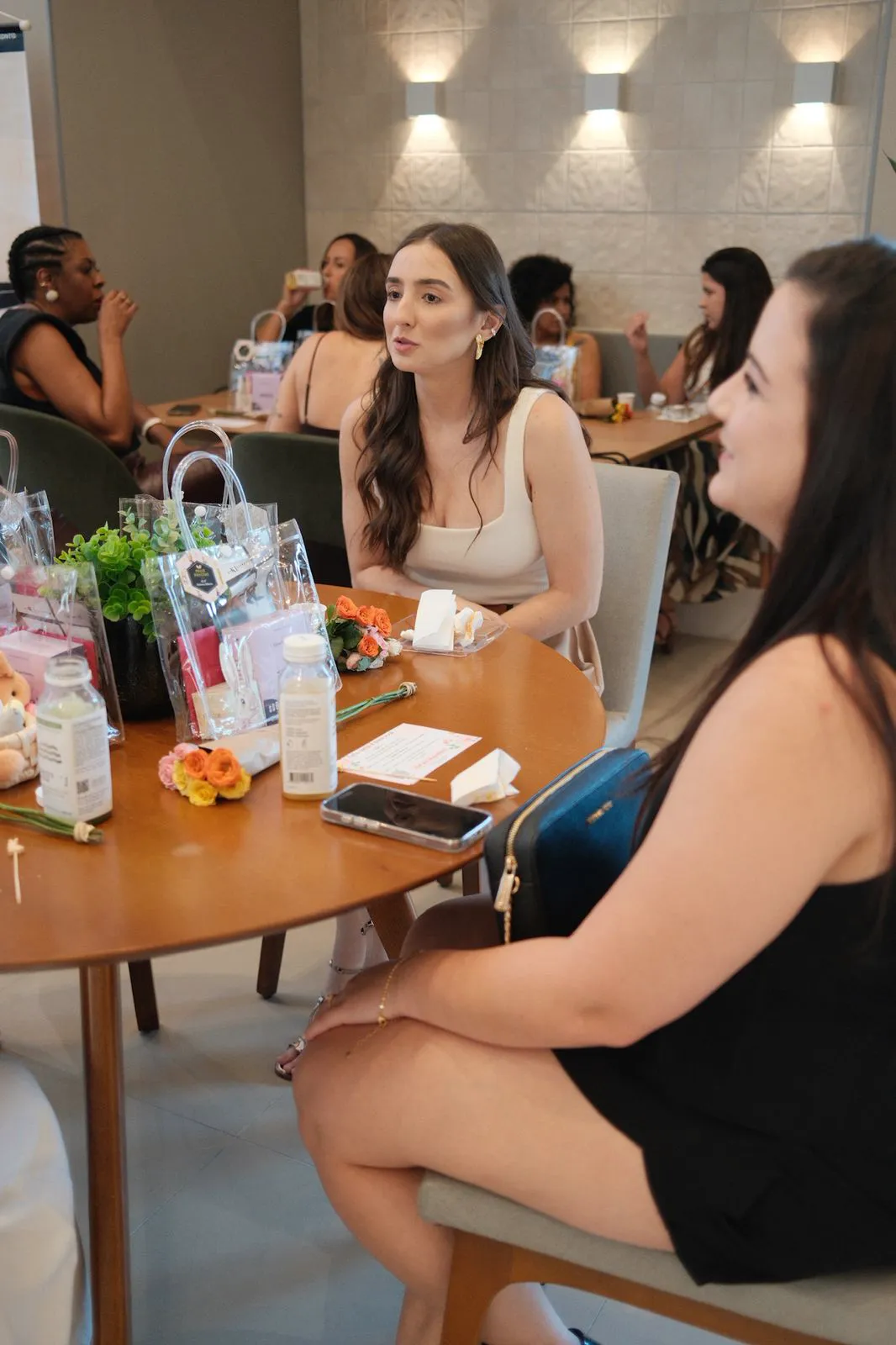Participantes em conversa ao redor da mesa, com os welcome kits