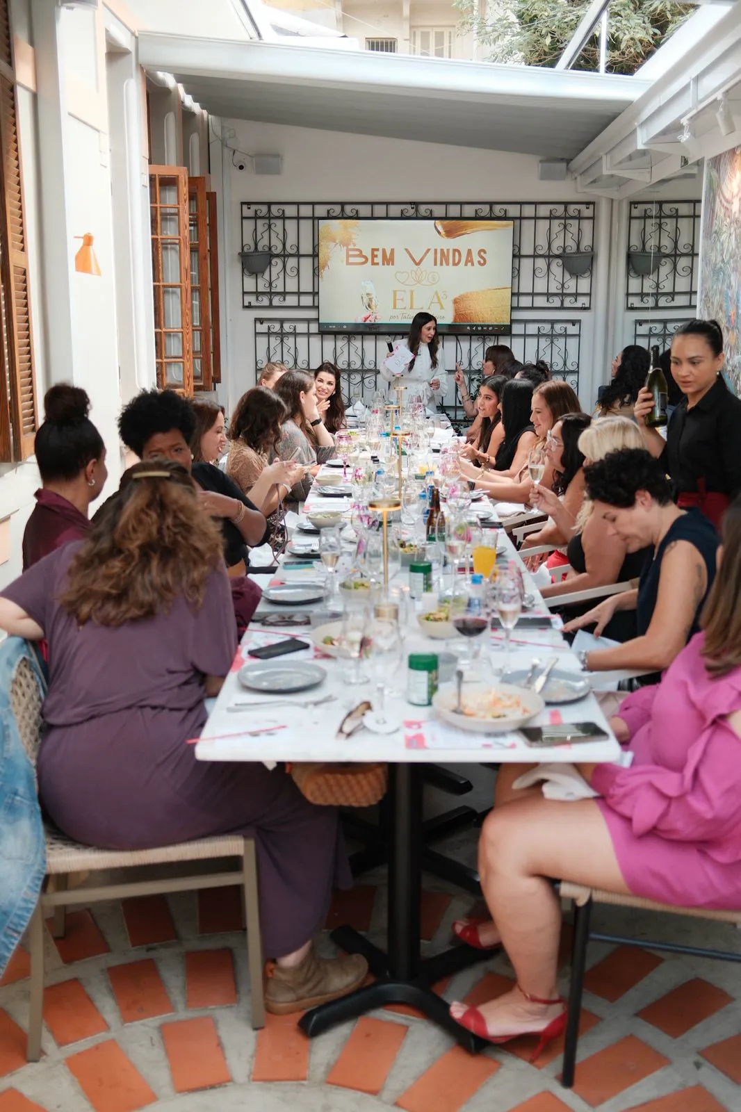 Mesa longa vista de cima, com as participantes em conversa