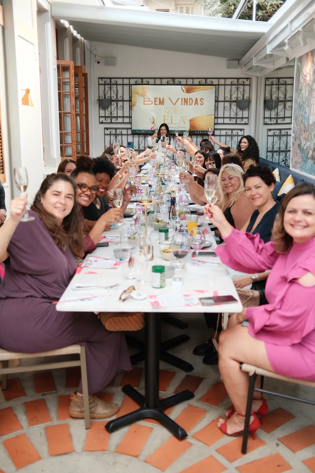 Mesa posta para o brunch, com o painel de boas-vindas ao fundo