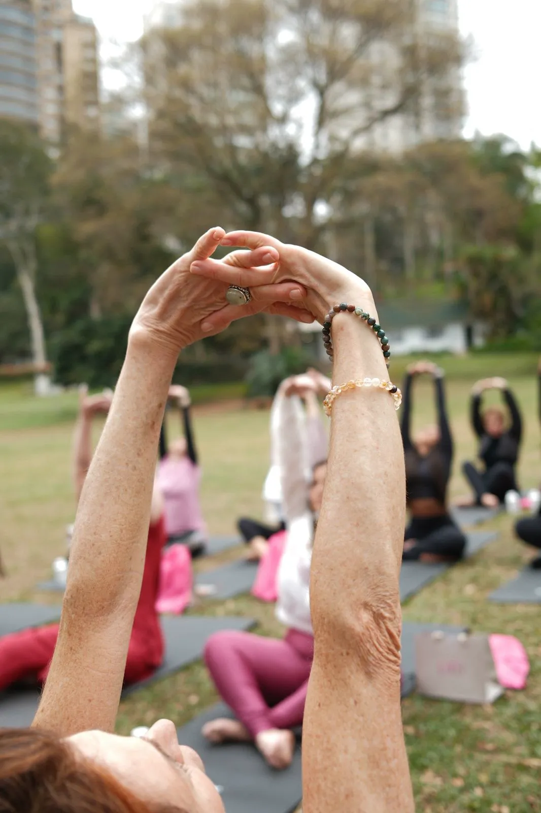 Mãos erguidas durante a prática de yoga ao ar livre